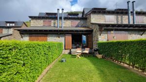 a house with a yard with two chairs in front of it at Casa Adosada en Alp Jardin y Wifi in Alp