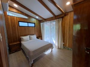 a bedroom with a bed and a large window at House in Playa Carrillo-Samara in Arbolito