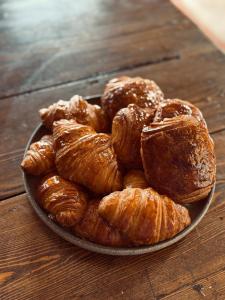 a plate of croissants on a wooden table at Maison Le Grand Saule in Bugnein