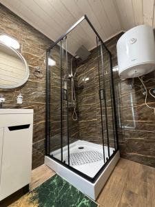a shower with a glass enclosure in a bathroom at А-фрейм У Ґазди in Synevyrsʼka Polyana +21 photos