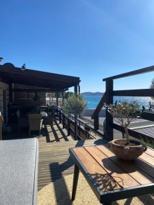 a wooden deck with a table and a tree on it at Mobile House on Drage Beach in Pakoštane