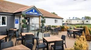 a restaurant with tables and chairs in front of it at Aqua bay whistable in Swalecliffe
