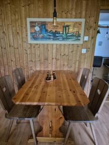 a wooden table in a room with chairs around it at Gemütliche Wohnung im Grünen in Herisau