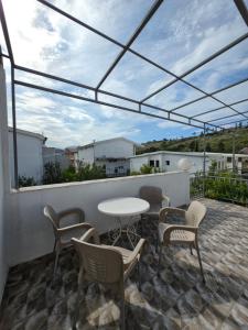 a patio with a table and chairs on a roof at Apartmani Viki in Sutomore