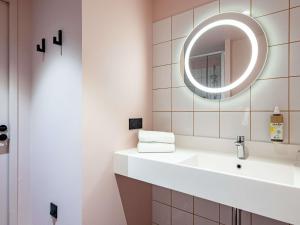 a bathroom with a sink and a mirror at greet Hotel Reims Tinqueux in Reims