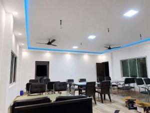 a room with chairs and tables and a blue ceiling at Jonaki Shantiniketan in Shānti Niketan