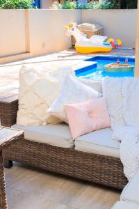 a wicker couch with pillows on top of a pool at Riverside 1 bedroom house for Two in Nelspruit