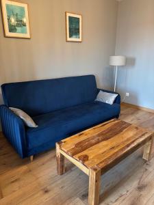 a blue couch and a coffee table in a living room at Apartament Nova Starówka 2 in Konin