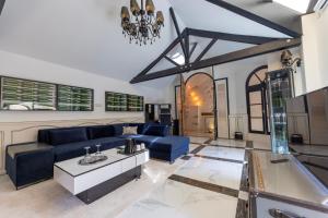 a living room with blue couches and a chandelier at Palazzo Di Acqua in Le Mans