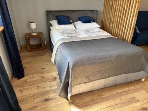 a bedroom with a large bed with blue pillows at Apartament Nova Starówka 2 in Konin
