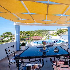 a patio with a table and chairs and a pool at Villa Love house in Vela Luka