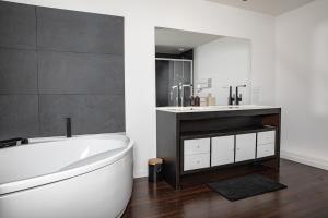 a bathroom with a white tub and a sink at La Forge de Fiac - Grande maison de charme avec vue campagne in Fiac +7 photos