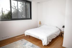 a white bedroom with a bed and a window at La Forge de Fiac - Grande maison de charme avec vue campagne in Fiac