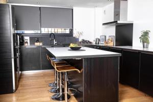 a kitchen with black cabinets and a white counter top at La Forge de Fiac - Grande maison de charme avec vue campagne in Fiac