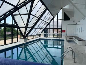 an indoor swimming pool with a glass ceiling at le Pullman in Deauville