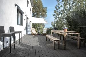 a wooden deck with a wooden table and benches at La Forge de Fiac - Grande maison de charme avec vue campagne in Fiac
