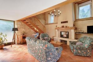 a living room with two chairs and a fireplace at Maison de vacances Le Tilleul in Saint-Pompont