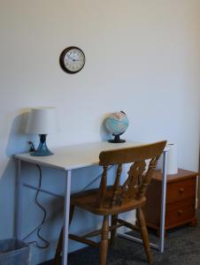 a desk with a chair and a clock on a wall at Peake Edge Home in Chesterfield