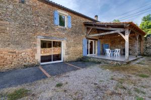 a brick house with a patio with tables and chairs at Maison de vacances Le Tilleul in Saint-Pompont