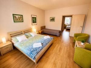 a bedroom with a bed and a living room at Penzion U Bohuša in Lednice