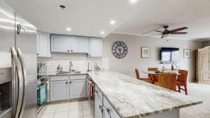 a kitchen with white cabinets and a clock on the wall at Ocean Block retreat with easy beach access & shared pools in Ocean City