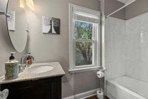 a bathroom with a sink and a tub and a window at Main Street Suite in Anoka +35 photos