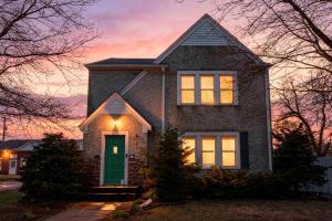 a house with a green door with a sunset in the background at Main Street Suite in Anoka