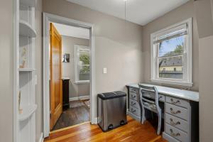 a home office with a desk and two windows at Main Street Suite in Anoka