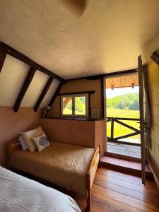 a bedroom with a bed and a window with a view at Maison Le Grand Saule in Bugnein +12 photos