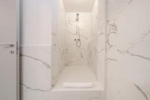 a white bathroom with a shower with a tub at Domus Alba in Teulada +23 photos