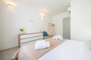 a white bedroom with a bed with two towels at Domus Alba in Teulada