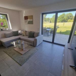 a living room with a couch and a glass table at Moderne Ferienwohnung,im fränkischen Seenland , 25 min Messe Nbg in Roth