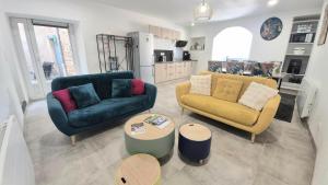 a living room with two couches and a table at La Traboule - Terrasse - 6 pers in Saint-Germain-Lembron