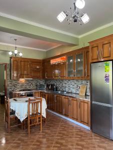 a kitchen with a table and a stainless steel refrigerator at Selim Guesthouse 2 in Lybeshë