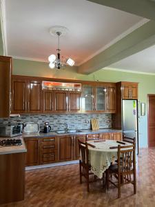 a kitchen with wooden cabinets and a table with chairs at Selim Guesthouse 2 in Lybeshë +7 photos