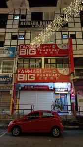 a red car parked in front of a building at Cozy Highland in Tanah Rata