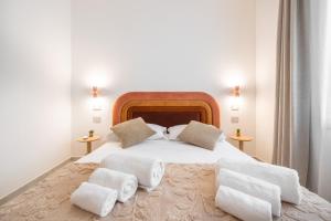 a bedroom with a large white bed with towels on it at Domus Luxi in Teulada