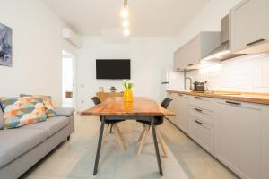a kitchen with a wooden table and a couch at Domus Luxi in Teulada