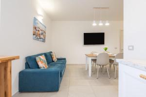 a living room with a blue couch and a table at Domus Soli in Teulada