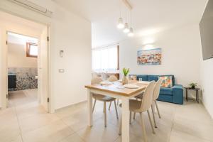 a dining room and living room with a table and chairs at Domus Soli in Teulada