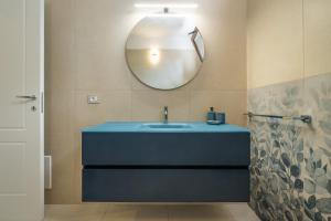 a bathroom with a blue sink and a mirror at Domus Soli in Teulada +19 photos