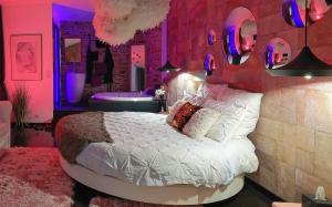 a bedroom with a bed and a bathroom with a tub at Le Lovt - LOVE ROOM NANTES in Nantes