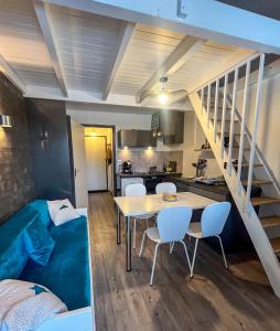a room with a table and chairs and a staircase at La Louvatière 28 in Mijoux