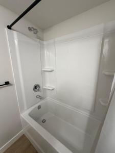 a white bathroom with a tub and a shower at The Onyx Suite Sleek Modern Space Private Entry in Regina +42 photos