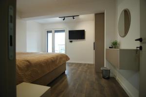 a bedroom with a bed and a flat screen tv at RiverSide Apartments in Veles