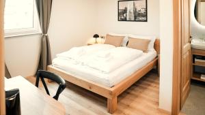 a bedroom with a bed with white sheets and a desk at Hiša 88 in Dutovlje