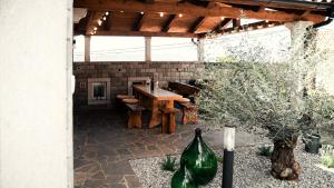 a stone patio with a wooden table and a wooden pergola at Hiša 88 in Dutovlje
