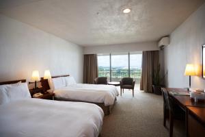 a hotel room with two beds and a desk at EM Wellness Kurashinohakko Lifestyle Resort in Kitanakagusuku +108 photos