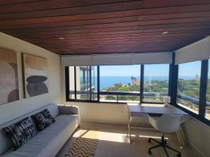a living room with a couch and a table and windows at Health Village Apartments in Cascais