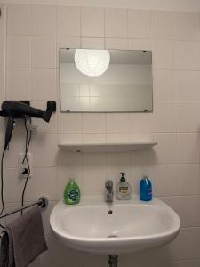 a white sink in a bathroom with a mirror at Modernes gemütliches Studio Zimmer in Elmshorn
